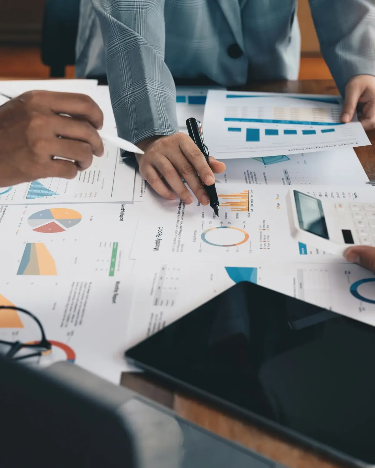 Two colleagues reviewing business performance charts and monthly reports at a desk, assessing their organisation's readiness